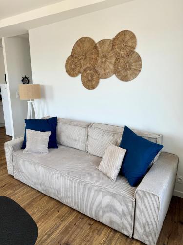a living room with a couch with blue pillows at Vue mer imprenable - Proche rue de Siam in Brest