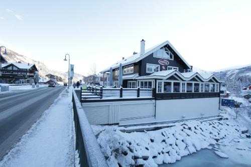 a house on the side of a road in the snow at Hemsedal Cafe Skiers Lodge in Hemsedal