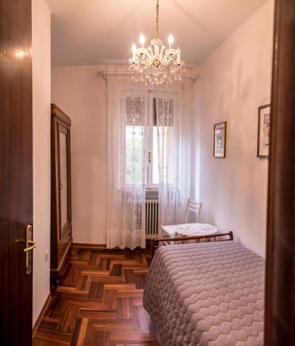 a bedroom with a bed and a chandelier at Casa Vacanze - SportHoliday House Segusino-Valdobbiadene in Segusino