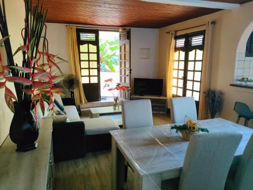 a living room with a table and chairs and windows at Bromelias in Le Robert
