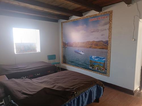 a bedroom with two beds and a large painting on the wall at Casa Rosita Sausa in Jauja