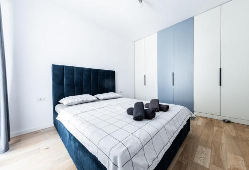 a bedroom with a large bed with a black headboard at Modern and Central Apartment in Timişoara