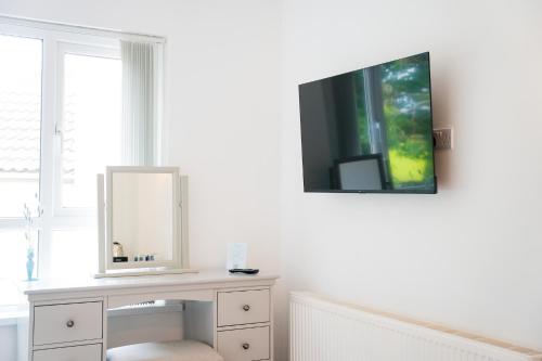a dressing table with a mirror and a tv on a wall at The Brambles Retreat in the Mournes in Annalong