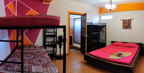 a room with two bunk beds and a mirror at Cool Vibes Beach Hostel in Dominical