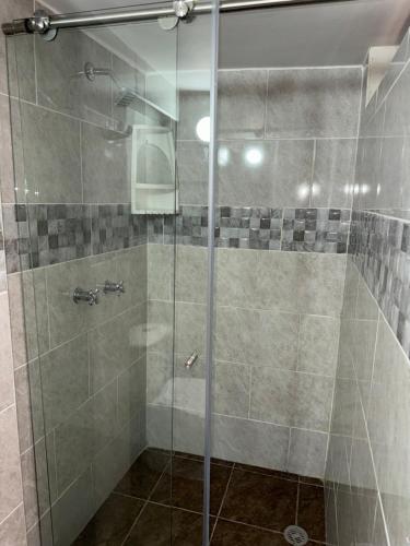 a shower with a glass door in a bathroom at Ceiba Rooms Hotel in Pereira