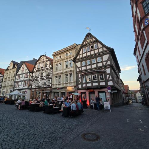 a group of people sitting in chairs in front of buildings at Alsfelder Wein-Suite in Alsfeld