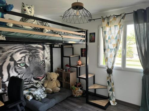 - une chambre avec des lits superposés et une fresque murale représentant des tigres dans l'établissement Villa au pieds du vercors, à Saint-Sauveur