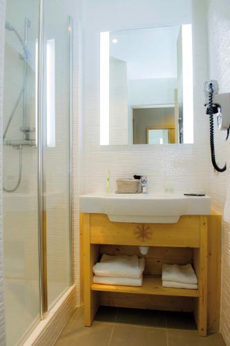 une salle de bain avec un lavabo et une douche dans l'établissement Club Vacances Bleues Les Alpes d'Azur, à La Salle Les Alpes