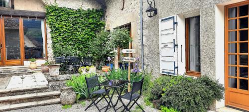 a patio with chairs and plants next to a building at Les Vagabonds du Mont in Chichilianne