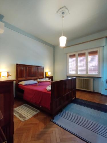 a bedroom with a bed with red sheets and a window at Villa LUCCA in Altopascio