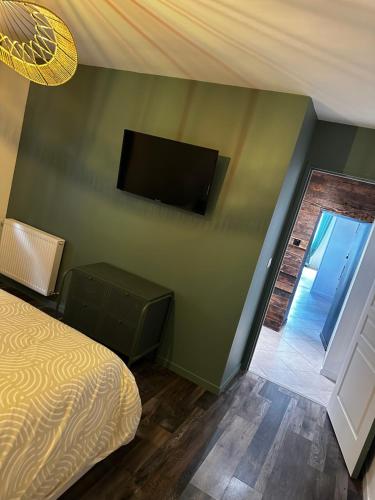 a bedroom with a bed and a flat screen tv on a wall at La Perle in Mers-les-Bains