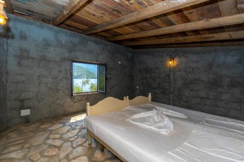 una camera da letto con un letto in una stanza con una finestra di Ujevara e Drinit - Bishaj a Shkodër