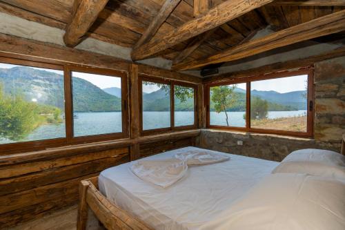una camera da letto con un letto in una stanza con finestre di Ujevara e Drinit - Bishaj a Shkodër