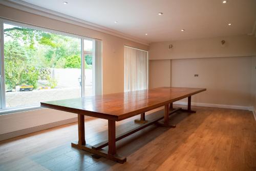 a wooden table in a room with a large window at The Brambles Retreat in the Mournes in Annalong