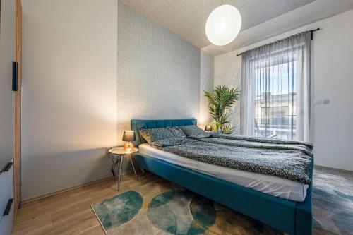 a bedroom with a blue bed and a window at Condos with Garage and Balcony in City Center in Budapest