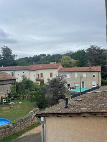 a group of buildings and a yard with a pool at La parenthèse dorée Studio à saint bel in Sain-Bel