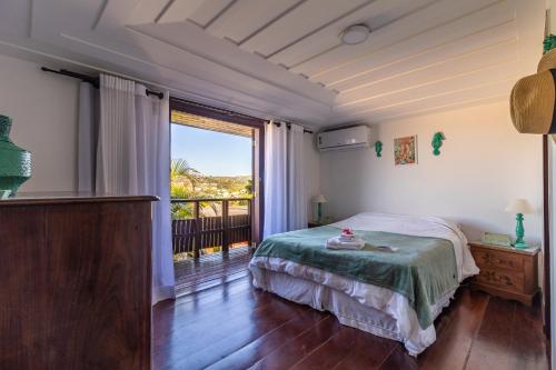 una camera da letto con un letto e una grande finestra di Villa Vermelha Ocean View a Búzios