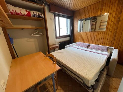une petite pièce avec un lit et une table dans l'établissement Studio meublé bon emplacement, à Chamonix-Mont-Blanc