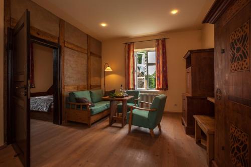 a living room with a bed and a table and a chair at Burghotel Stargard in Burg Stargard