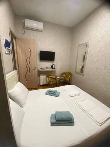 a hotel room with a bed with two towels on it at Anna'S Home in Kutaisi