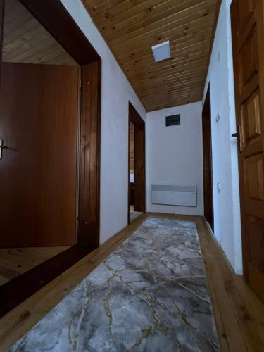 an empty hallway with a door and a rug at Vikendica u srcu Bjelasnice in Trnovo