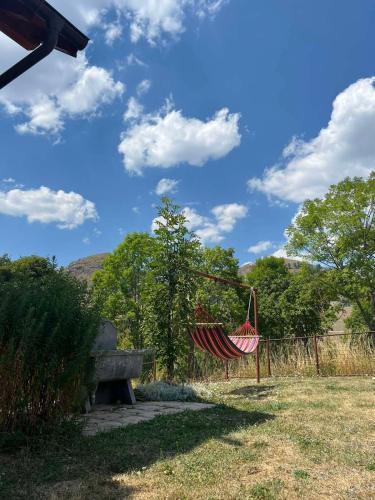 a hammock in a park with a bench at Vikendica u srcu Bjelasnice in Trnovo