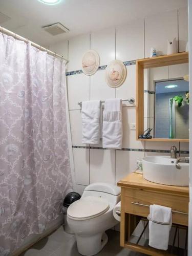 a bathroom with a shower curtain and a toilet and a sink at SuiteDelux Oceanview Marbella 3BDR in Juan Pedro