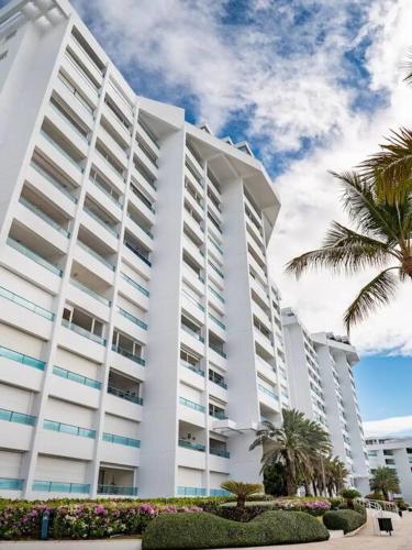 a large white building with palm trees in front of it at SuiteDelux Oceanview Marbella 3BDR in Juan Pedro