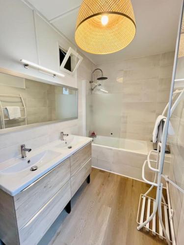 une salle de bain avec un lavabo, une baignoire et un miroir dans l'établissement République 3, Gare, Centre-ville, à Bourgoin-Jallieu