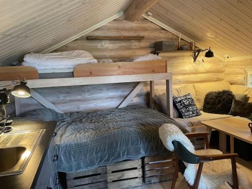 a bedroom in a log cabin with a bed and a desk at Åsbøseterdalen in Liverud