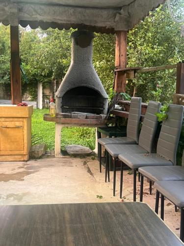 an outdoor pizza oven with chairs and a table at Studio St Florentin in Saint-Florentin