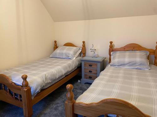 two twin beds in a bedroom with a nightstand and sidx sidx sidx at Oldshorecroft in Sheigra