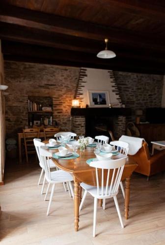 - une table en bois avec des chaises blanches dans l'établissement cancaleloca, à Cancale
