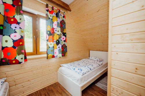 a small room with a bed in a wooden cabin at Kolorowe Karkonosze in Przesieka