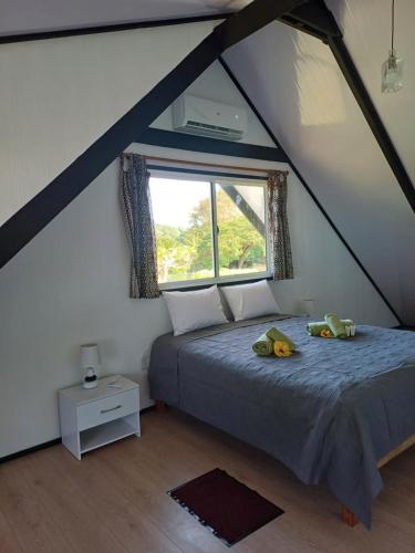 a bedroom with a bed with two stuffed animals on it at Villa VAIROARII Moorea in Afareaitu