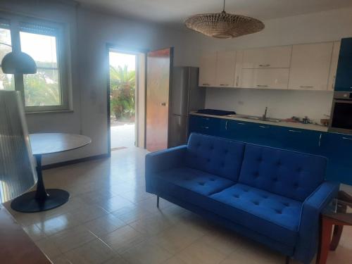 Una sala de estar con un sofá azul y una mesa. en Casa Dormio, en Monopoli