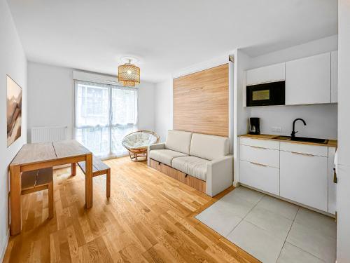 une cuisine et un salon avec un canapé et une table dans l'établissement Le Séjour Distingué à Romainville, à Romainville