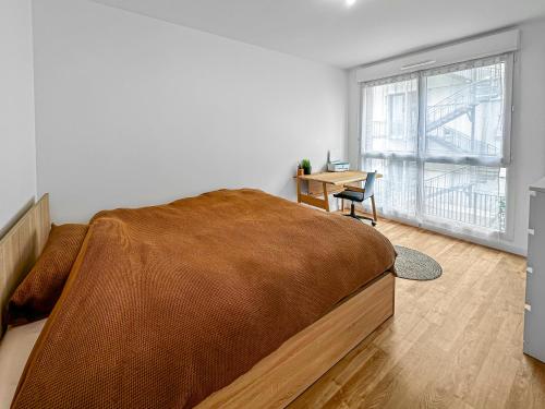une chambre avec un lit, un bureau et une fenêtre dans l'établissement Le Séjour Distingué à Romainville, à Romainville