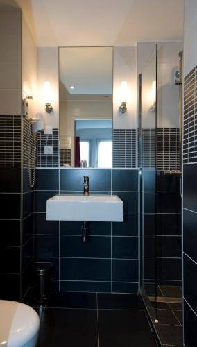 une salle de bain avec un lavabo et un miroir dans l'établissement Hôtel du Musée de l'Eau, à Pont-en-Royans