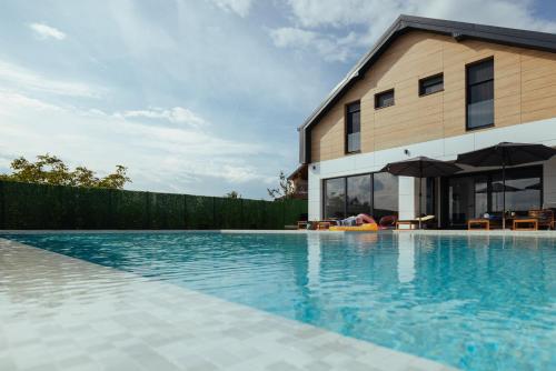a swimming pool in front of a house at Vila Pogled in Vrdnik