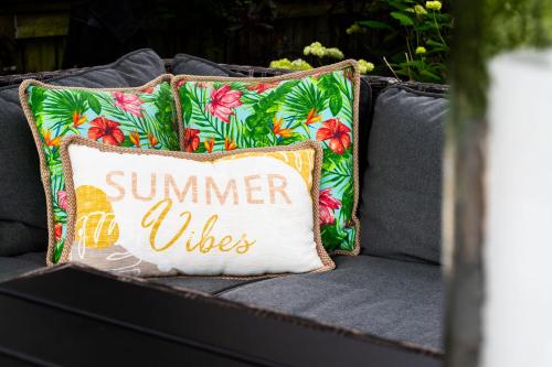 a summer welcomes pillow on a gray couch at Charming riverside cottage, walk to beach in Wasaga Beach