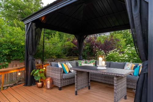 a gazebo with a table and a couch at Charming riverside cottage, walk to beach in Wasaga Beach