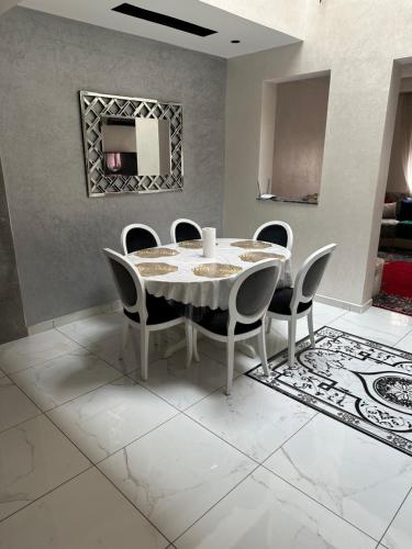 een eetkamer met een witte tafel en stoelen bij Riad Jad - Sweet Duplex Appartement in Marrakesh