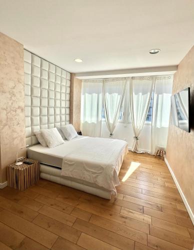 une chambre avec un grand lit et de grandes fenêtres dans l'établissement Magnifique loft atypique, à Tarascon