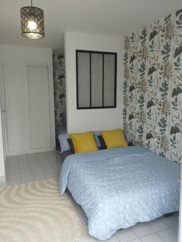 une chambre avec un lit avec des oreillers jaunes dans l'établissement Charmant studio à Tours, à Tours