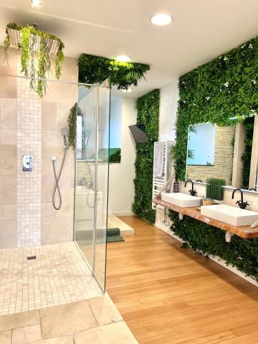 La salle de bains est pourvue de 2 lavabos et d'un mur vert. dans l'établissement Magnifique loft atypique, à Tarascon