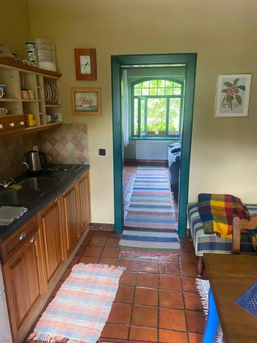 a kitchen with a tile floor with a sink and a window at Apartmán Dům U Koulí in Prameny