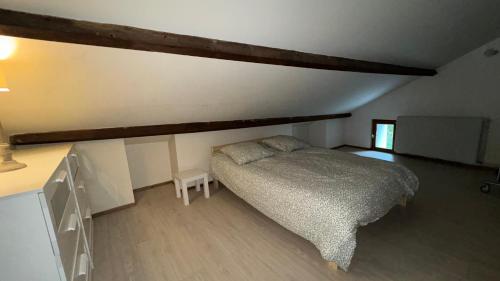 - une chambre mansardée avec un lit et un bureau dans l'établissement 7 min de Dole Maison 110 m2 6 couchages 3 chambres spacieuses, à Champvans