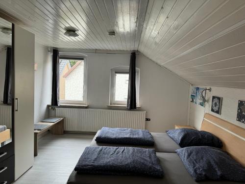 two beds in a large room with two windows at Familienferienwohnung in Eckernförde