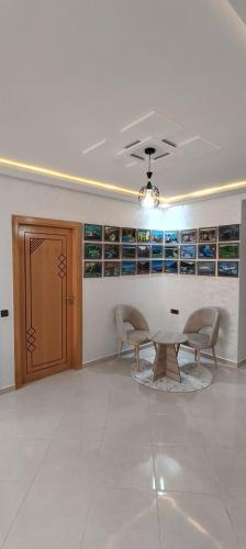 a living room with a table and two chairs in it at La Maison Attawba in Beni Mellal